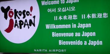 Schild am Narita Flughafen, auf dem "Willkommen in Japan" in verschiedenen Sprachen steht