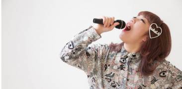 Beim Karaoke: Singende Frau mit Mikrofon