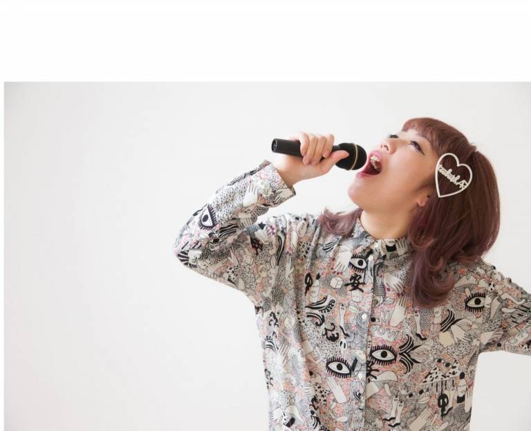 Beim Karaoke: Singende Frau mit Mikrofon