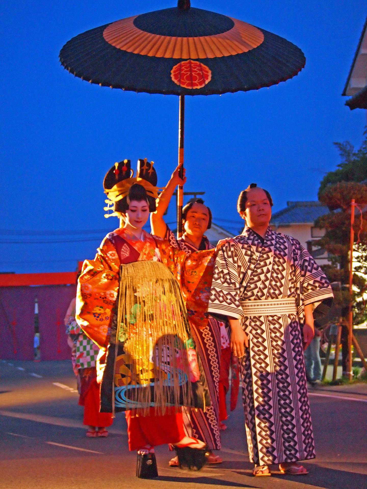 Oiran auf der Straße mit einem Sonnenschirmträger