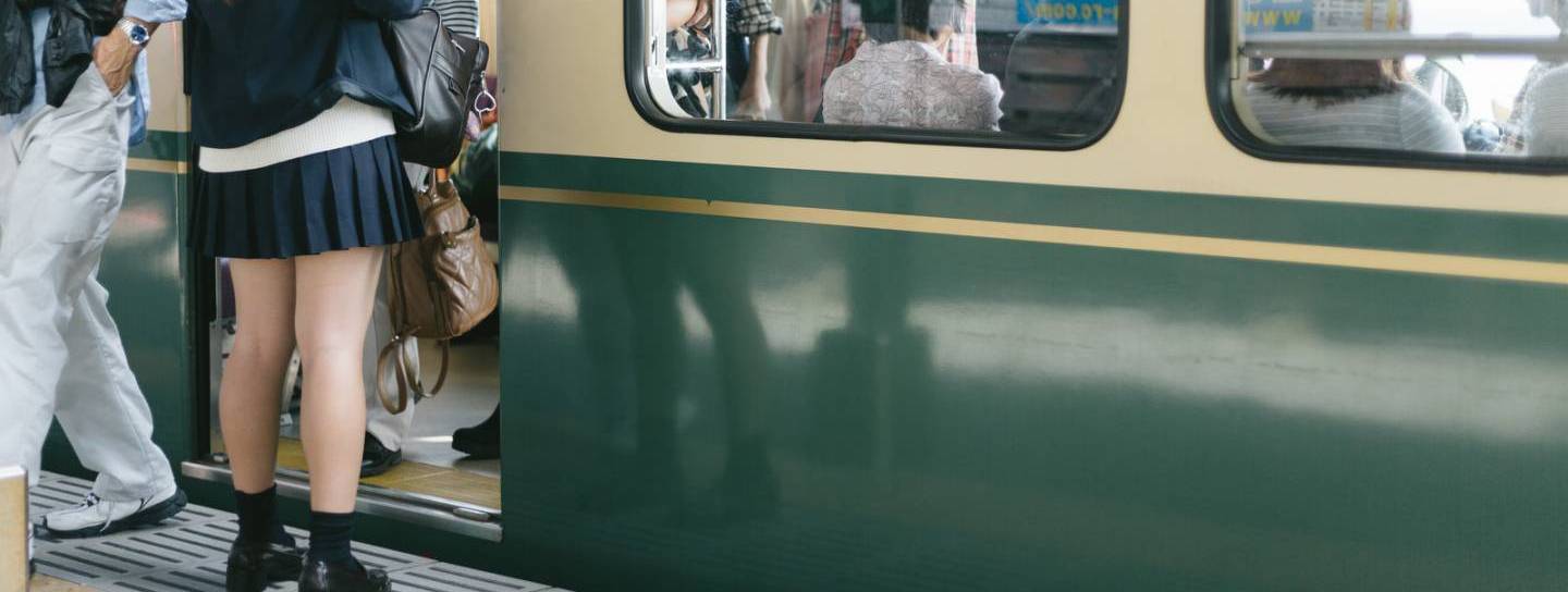japanischer Zug mit einsteigenden Passagieren am Bahnhof