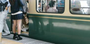 japanischer Zug mit einsteigenden Passagieren am Bahnhof