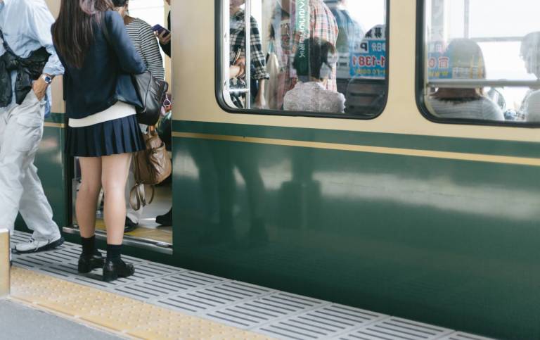 japanischer Zug mit einsteigenden Passagieren am Bahnhof