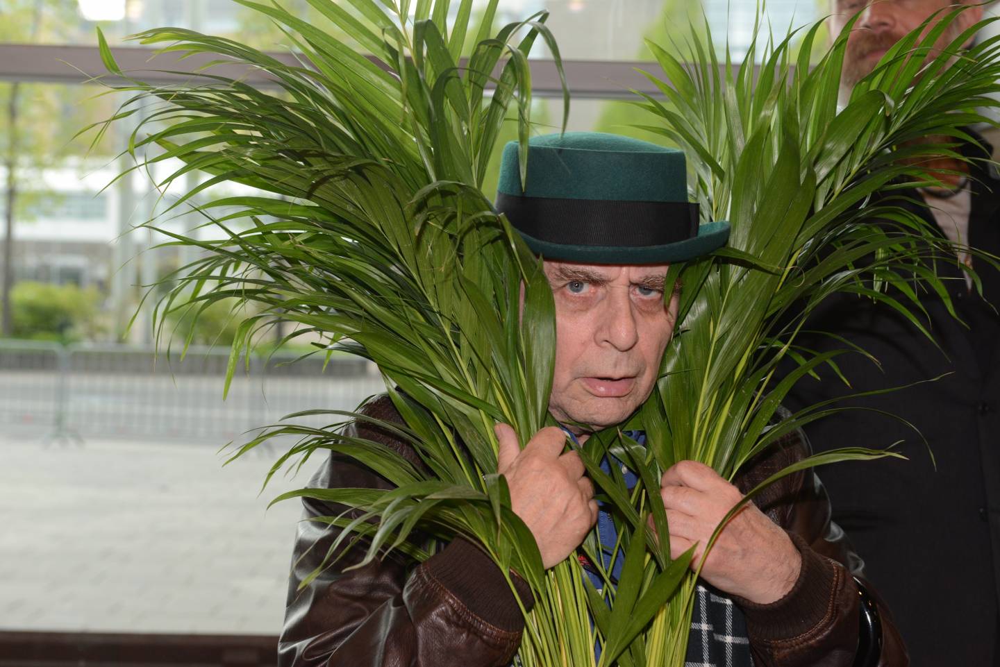Sylvester McCoy versteckt sich hinter einer Pflanze