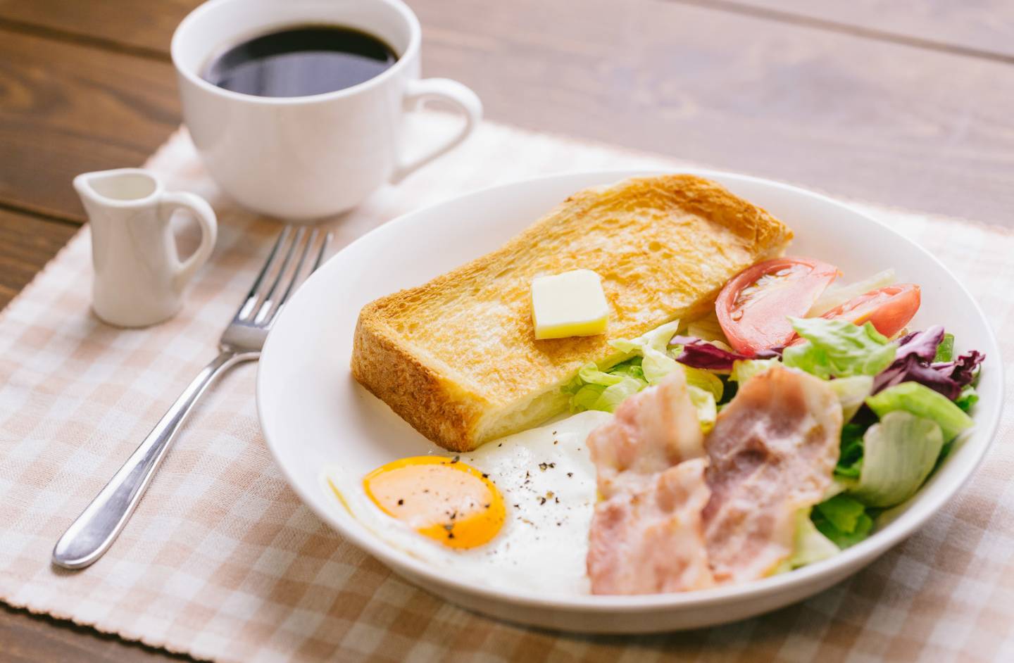 Westliches Frühstück mit Toast, Bacon, Spiegelei und Kaffee