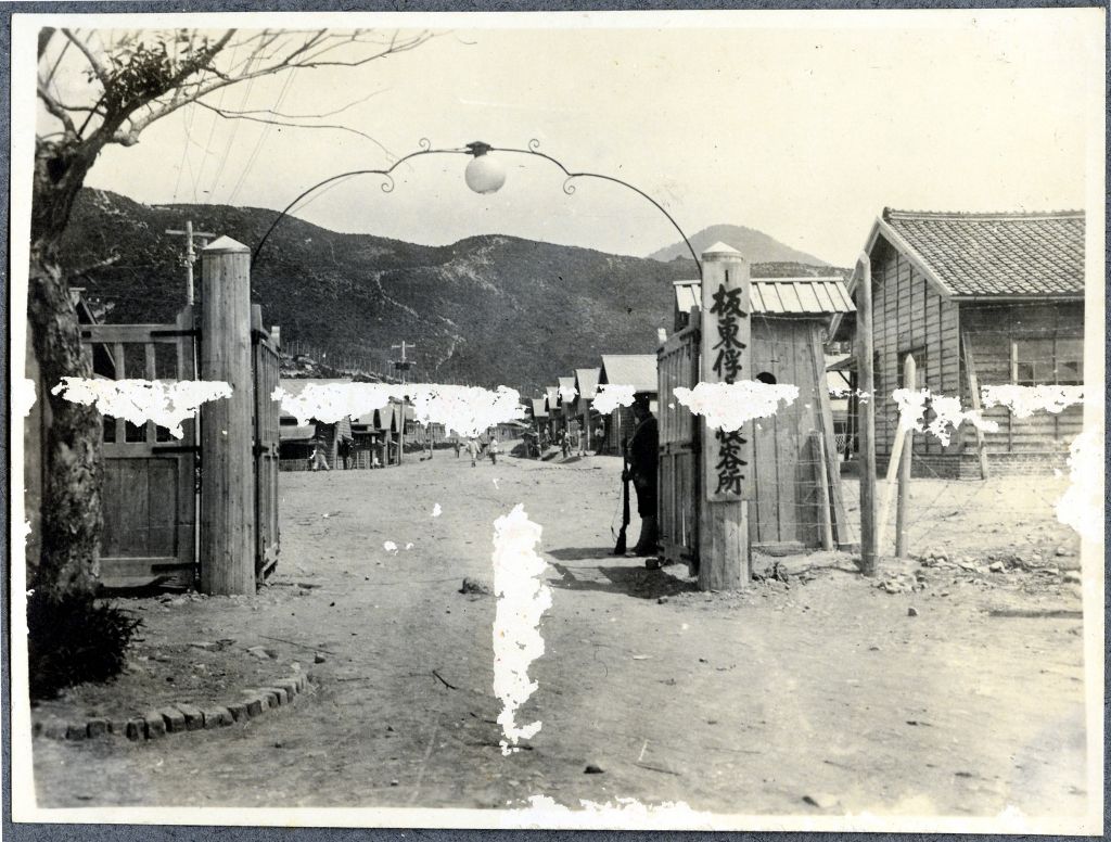 Blick auf das Kriegsgefangenenlager durch das Eingangstor.