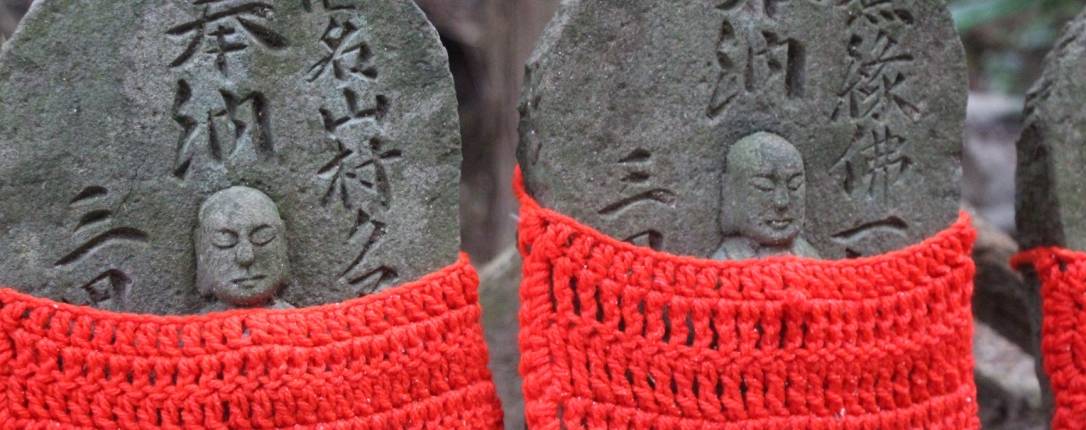 Alte Statuen in rotem Strickkostüm.