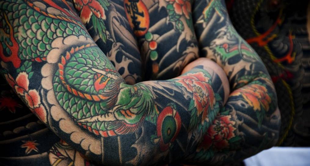 Traditonelles Ganzkörper-Tattoo mit Drachen- und Blumenmotiven.