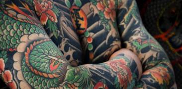 Traditonelles Ganzkörper-Tattoo mit Drachen- und Blumenmotiven.