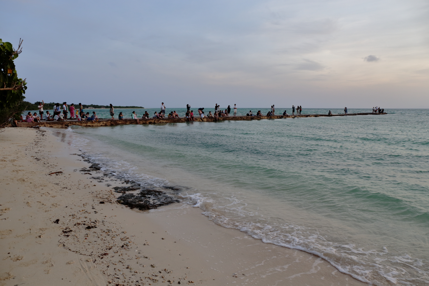 West-Pier auf Taketomi-jima. Besucher versammeln sich, um das Abendlicht zu betrachten.