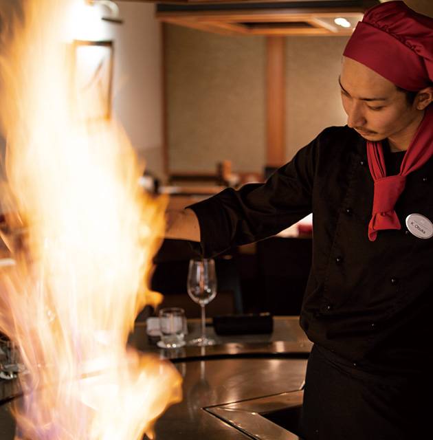 flamme über einem teppanyaki Grill mit koch