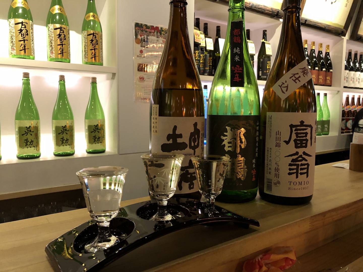 Sake in Flaschen und Gläsern auf einer Theke