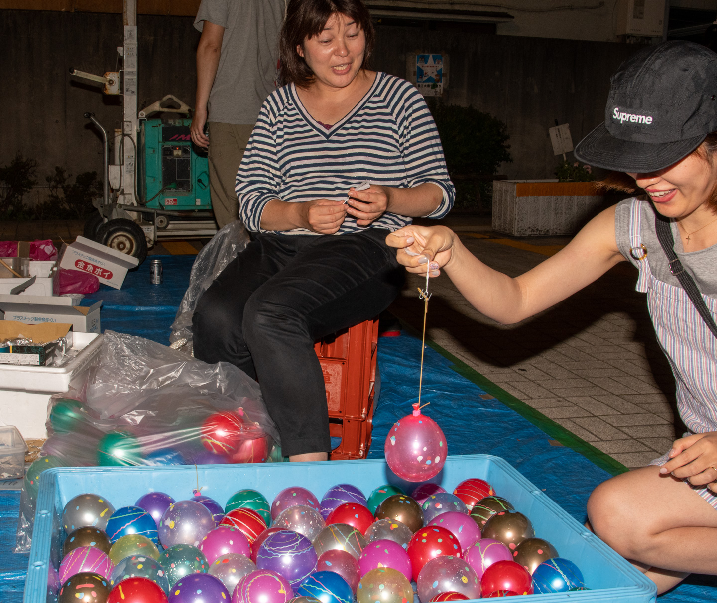 Frau angelt Luftballon aus Becken mit Wasser