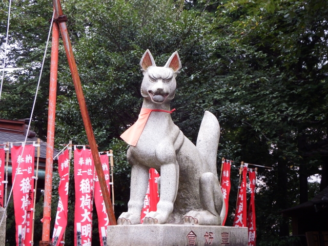 Kitsune-Statue in rotem Latz