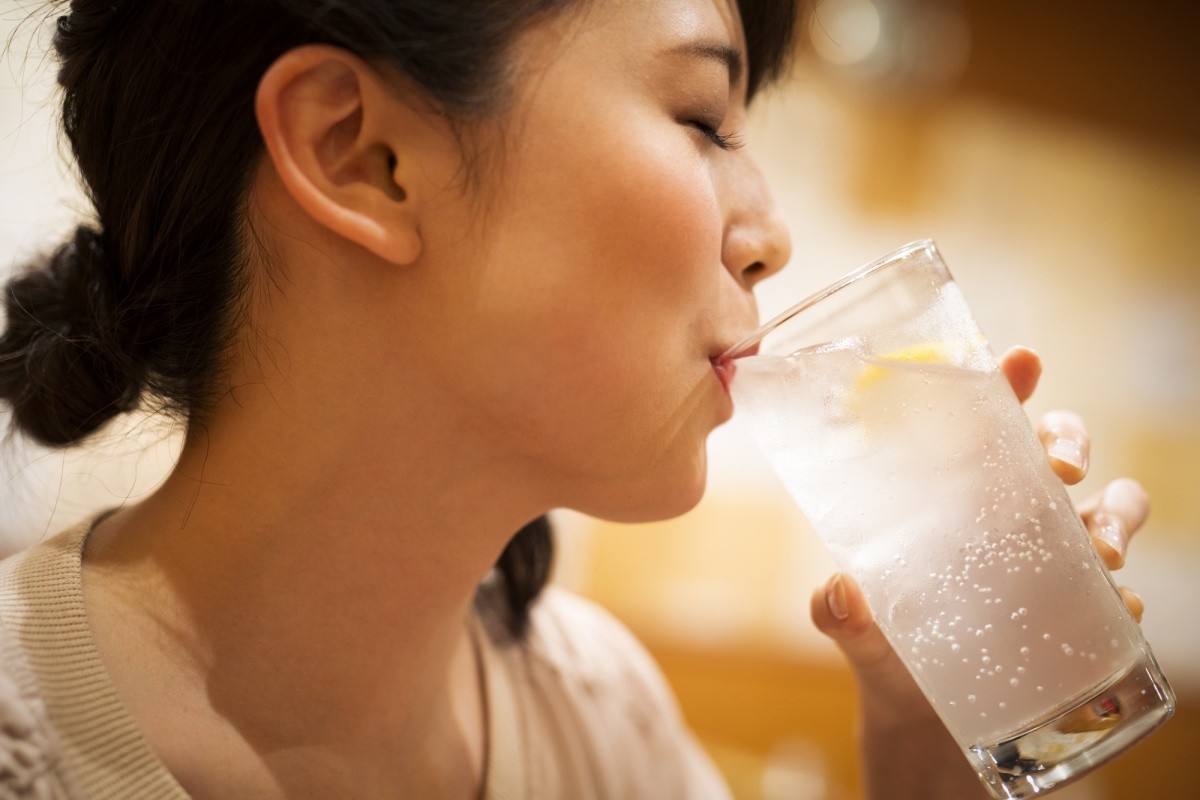 Frau, die gerade ein Soda-Mixgetränk trinkt