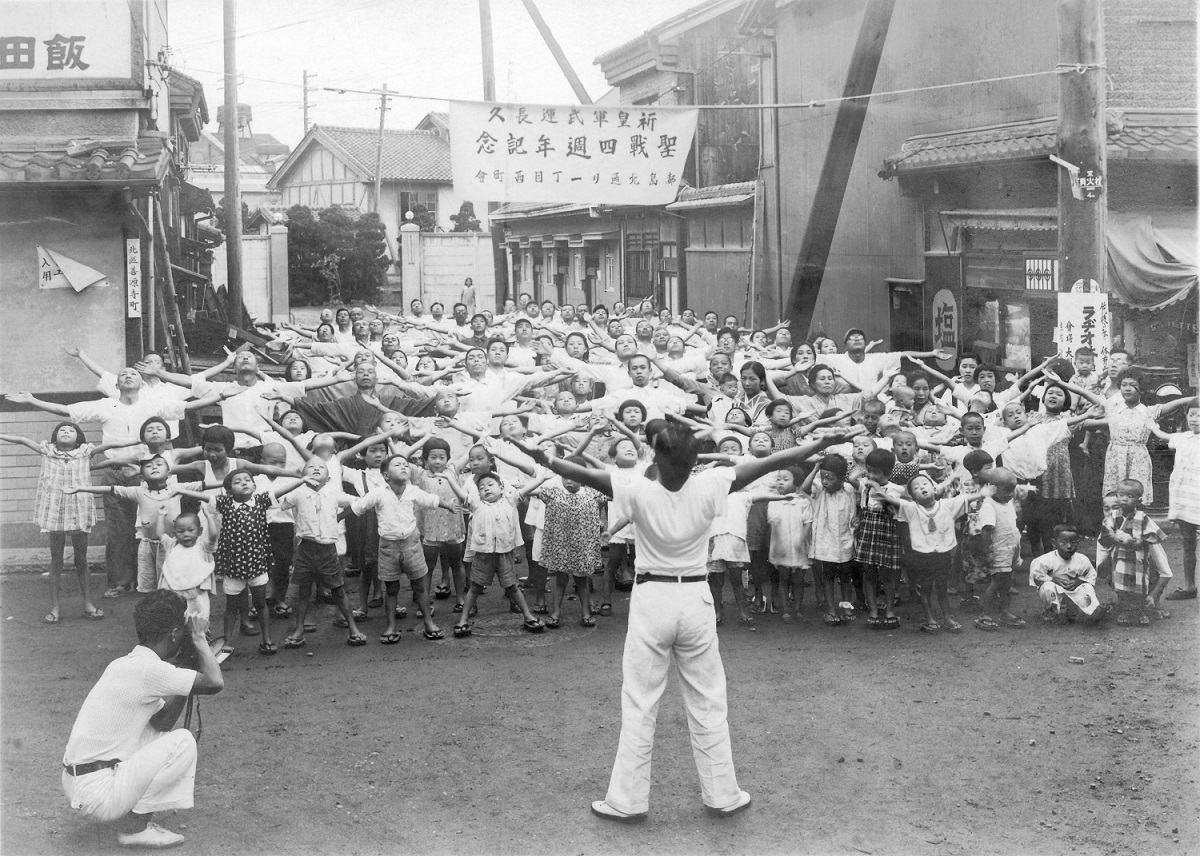 Gruppe von Kindern und Erwachsenen bei der Radiogymnastik (Zweiter Weltkrieg)