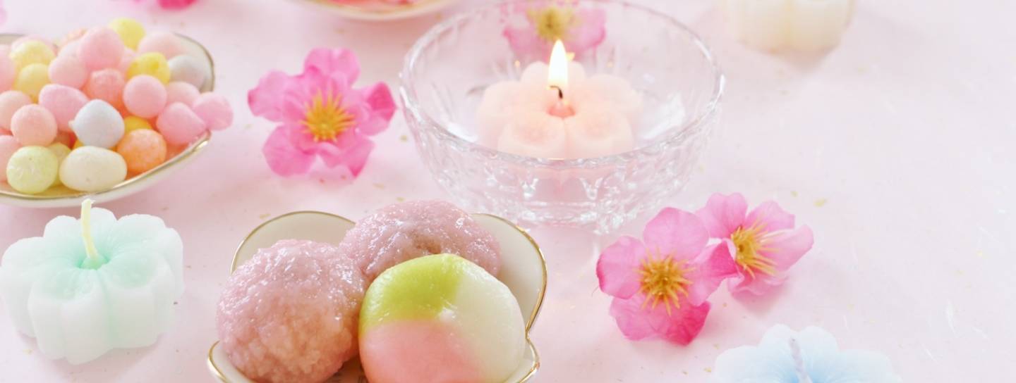 Süßigkeiten, Blumen und Kerzen zum Hina Matsuri (Mädchenfest)