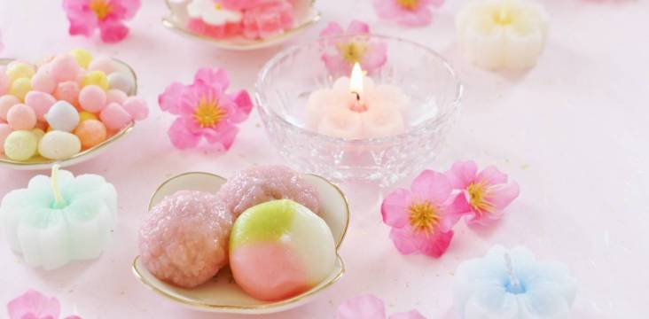 Süßigkeiten, Blumen und Kerzen zum Hina Matsuri (Mädchenfest)