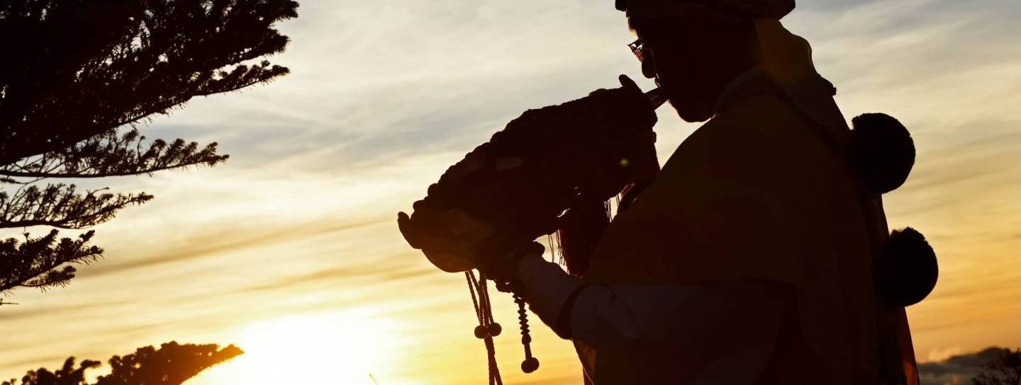 Ein Shugenja bläst ein Muschelhorn im Sonnenaufgang