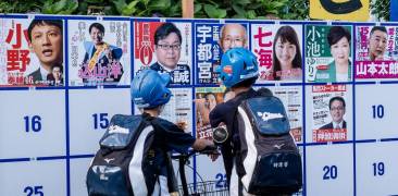 05. Juli 2020: Teenager schauen auf Wahlplakete verschiedener Kandidaten in Tokyo.