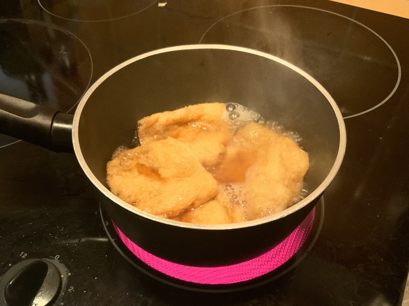 Tōfu-Taschen in Sud kochen