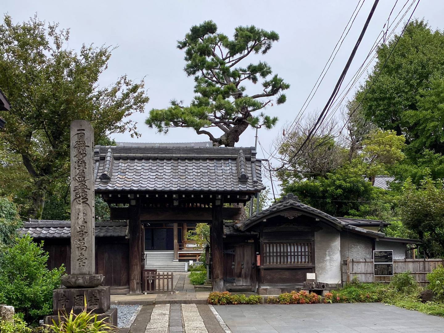 Vor dem Tempel Kōkoku-ji, lange gepflasterter Weg, überdachtes Holztor