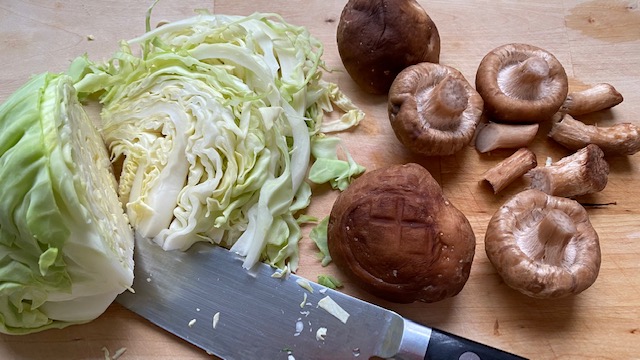 Urkohl wird in feine Streifen geschnitten (Shiitake liegen bereit)