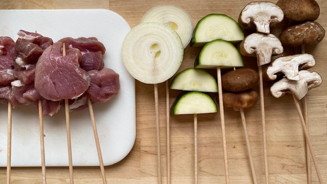 Rohes Fleisch, Gemüse und Pilze auf Holzspießen