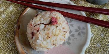 Reisbällchen mit Kirschblüten auf Tellereben mit Essstäbchen