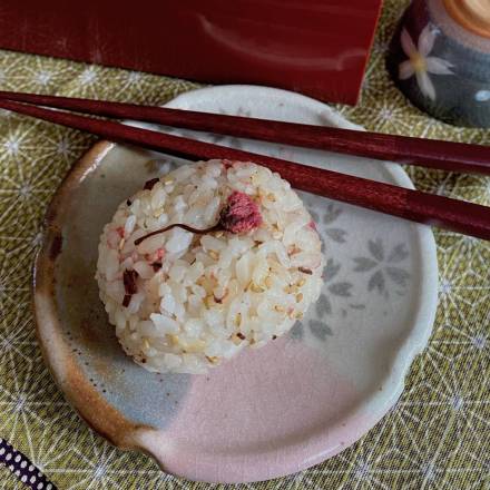 Reisbällchen mit Kirschblüten auf Tellereben mit Essstäbchen