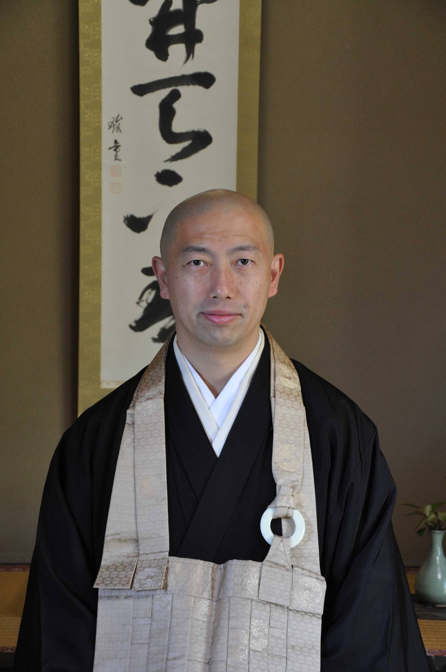 Hirai Shōshū, der Hauptpriester des Zenshōan-Tempels in Tōkyō vor einer Kalligraphie.