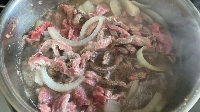 Rindfleisch wird Dashi-Brühe und Gemüse hinzugefügt