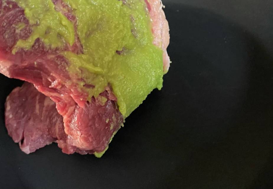 Rohes Steak mit Wasabi vor schwarzem Hintergrund