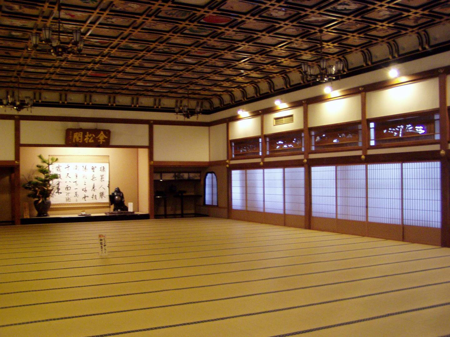 Haupthalle des Zen-Tempels Eihei-ji in Fukui mit Tatami-Fußboden und Kalligraphie an der Wand, goldbraunes Licht