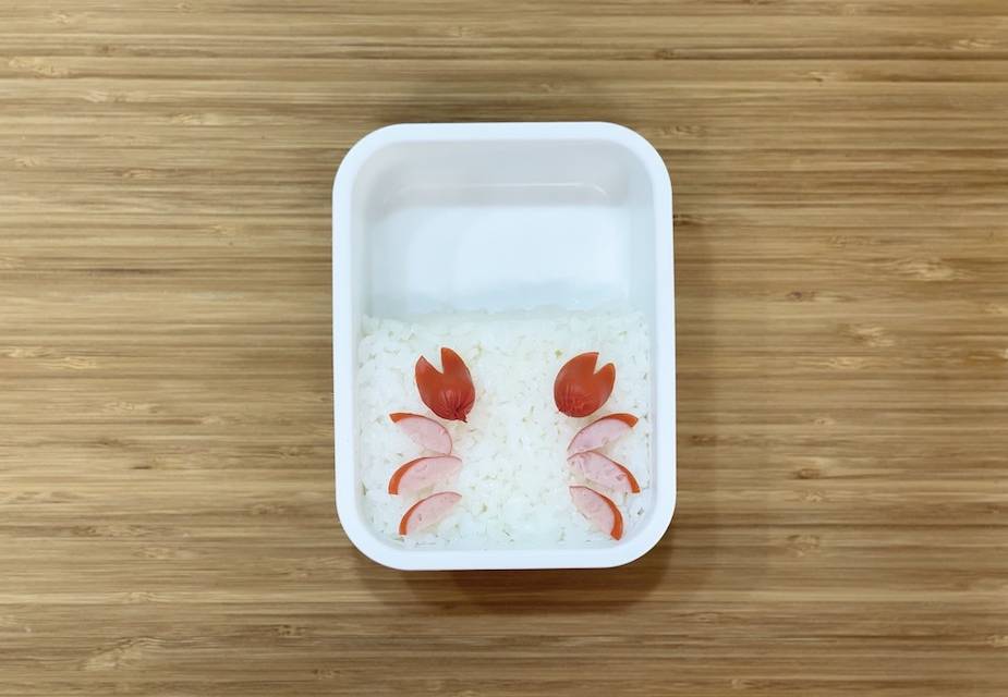 "Scheren des Krebses" auf Reis in weißer Bento-Box