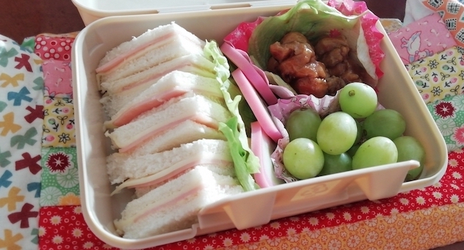 Bento-Box mit Sandwiches, Obst und Fleisch