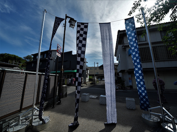 Batikstoffe in Blautönen zum Trocknen aufgehängt bei einem Fest in Arimatsu