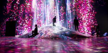 Ausstellung teamLab Borderless, pink-blaue Lichtinstallation mit staunenden Besuchern