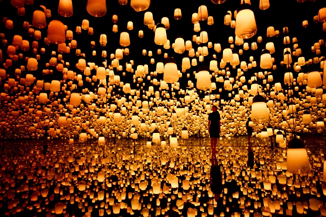 teamLab Borderless Ausstellung mit zahllosen, gelb leuchtenden Lampen und staunenden Besuchern