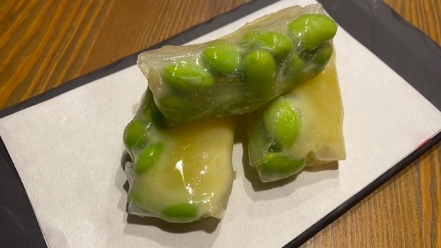 Edamame in Reispapier, serviert auf weißem Teller