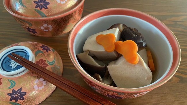 Koyadofu serviert in kleiner Schüssel mit Karottenblumen dekoriert und Stäbchen auf Extrateller an der Seite