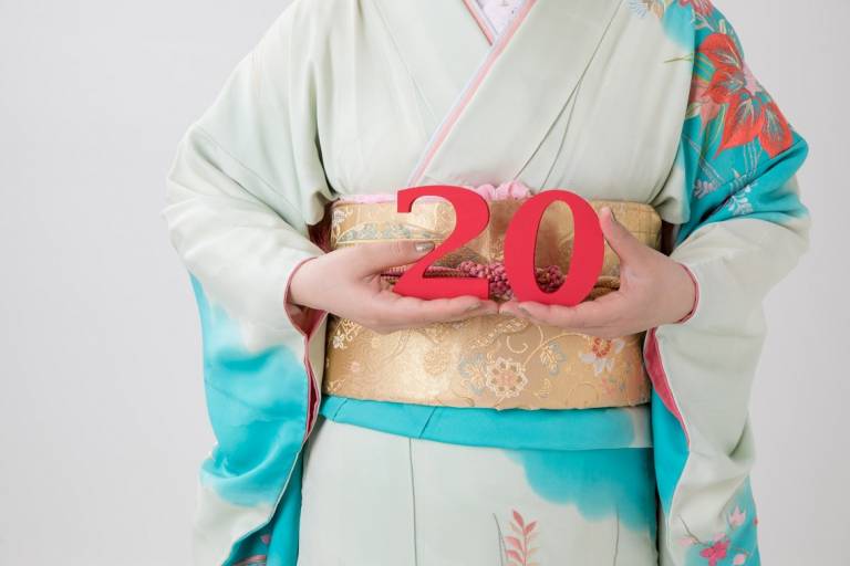 Japanerin im Kimono hält eine rote 