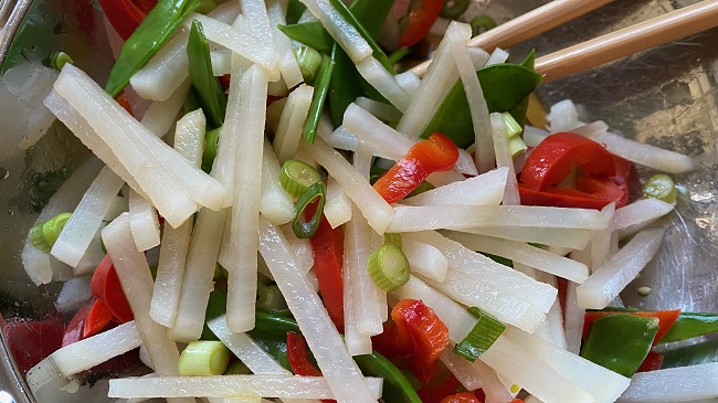 Gemüsestreifen mit Frühlingszwiebeln vermischt