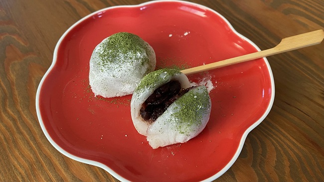Fertige Uguisu-Mochi, aufgeschnitten auf rotem Teller serviert