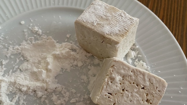 Tofu-Stücke werden in Stärke gewälzt