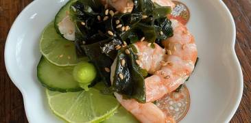Garnelen-Wakame-Salat auf blumenförmigem Teller serviert