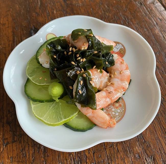 Garnelen-Wakame-Salat auf blumenförmigem Teller serviert