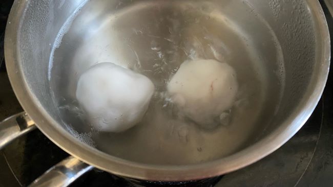 Zwei Reismehlkugeln in kochendem Wasser