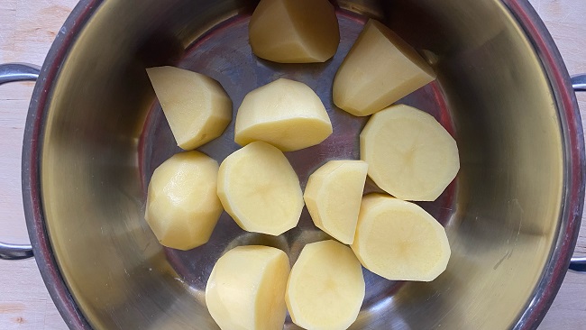Geviertelte, geschälte Kartoffeln im Topf ohne Wasser