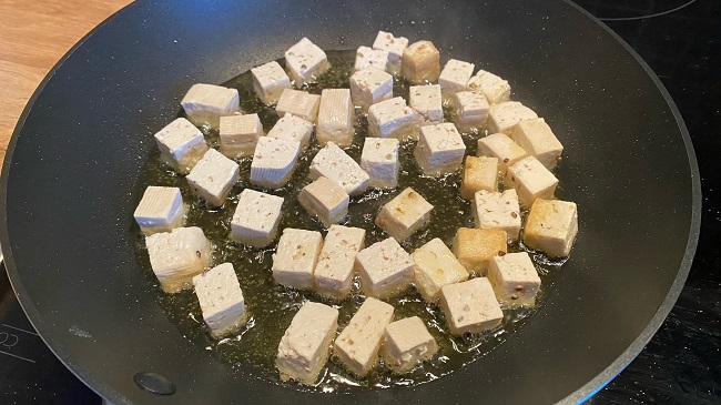 Tofuwürfel werden in der Pfanne knusprig angebraten